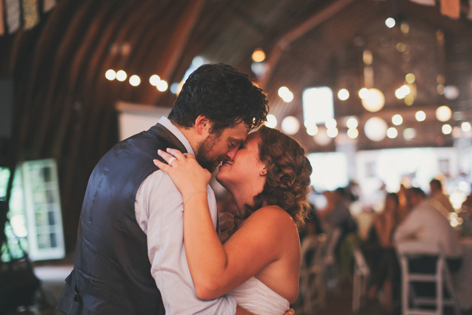 The bride and groom share a first dance as The Appleseed Collective plays blue grass music live at the Blue Dress Barn in Benton Harbor photographed by Ann Arbor Michigan wedding photographer Heather Jowett.