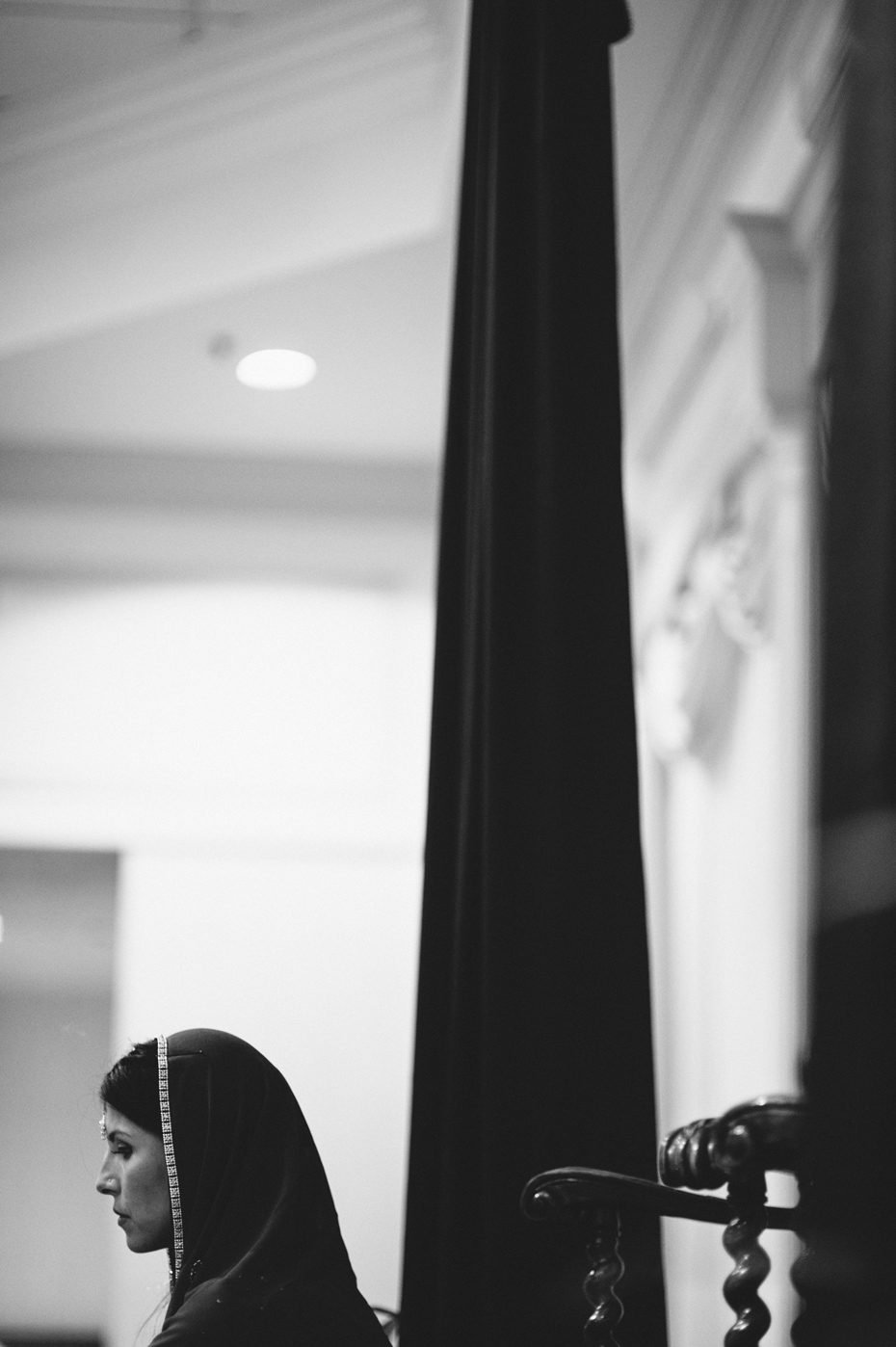 A bride in a veil awaits her groom in a traditional hindu wedding ceremony.