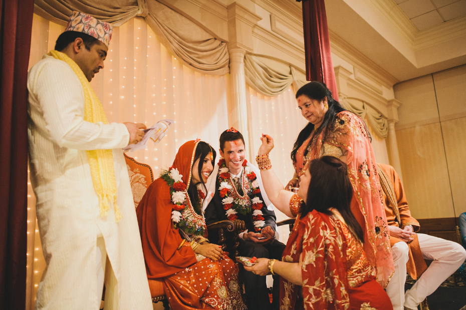 The bride and groom are blessed by family members during a traditional Nepali Hindu wedding ceremony.