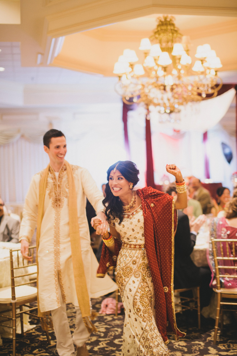 The bride and groom enter their hindu wedding reception, by Ann Arbor wedding photographer Heather Jowett.