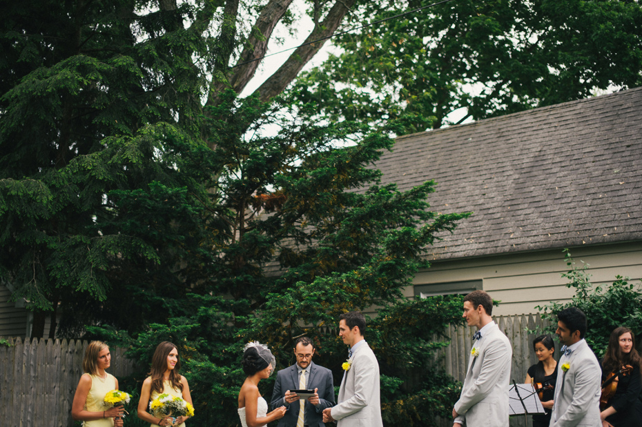 The bride and groom are married in a backyard wedding ceremony, by Ann Arbor wedding photographer Heather Jowett.