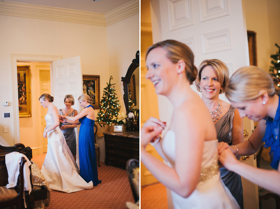 A bride is helped into her dress by her mother and maid of honor at the Fountainview mansion, photographed by Detroit Wedding Photographer Heather Jowett.