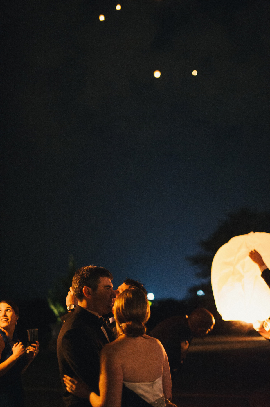 The bride and groom watch chinese lanterns in the sky at a wedding reception at The Fountainview Mansion in Auburn Alabama, photographed by Ann Arbor Wedding Photographer Heather Jowett.