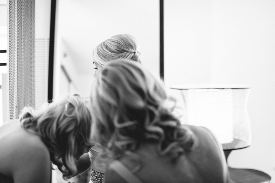 A bride gets into her dress in Chicago, photographed by Ann Arbor Wedding Photographer, Heather Jowett.