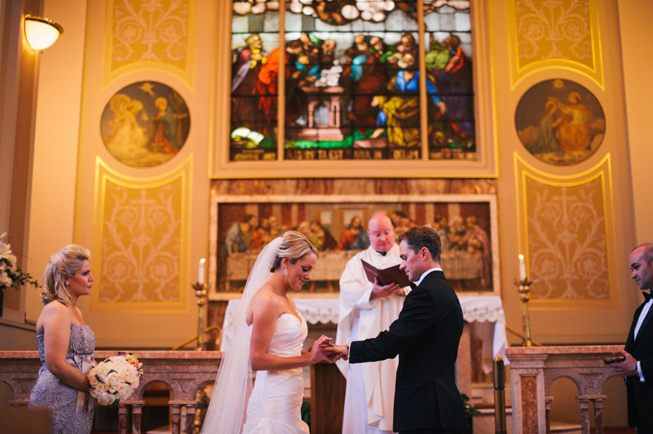 The bride and groom exchange rings in a catholic wedding mass, photographed by Ann Arbor Wedding Photographer, Heather Jowett.