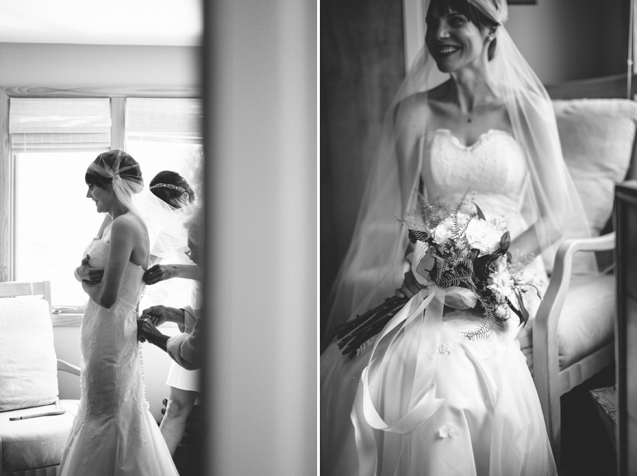 A black and white photo of a bride being helped into her wedding dress before her backyard wedding, photographed by Ann Arbor wedding photographer, Heather Jowett.