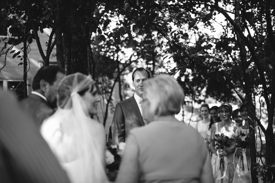 The groom sees his bride for the first time in their backyard wedding ceremony by Detroit Michigan wedding photographer, Heather Jowett.