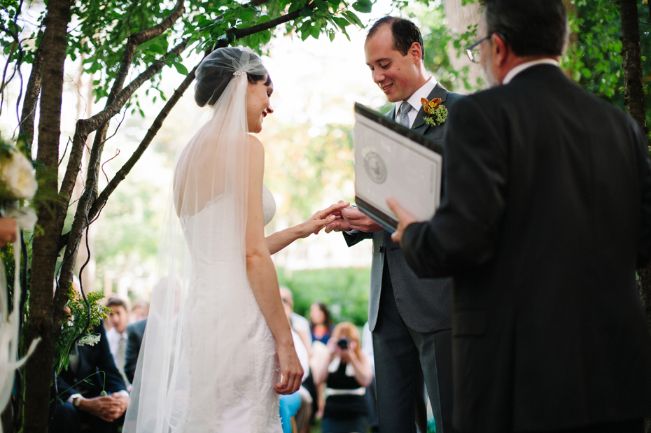 Bride and groom exchange rings during A backyard wedding by Detroit Michigan wedding photographer, Heather Jowett.