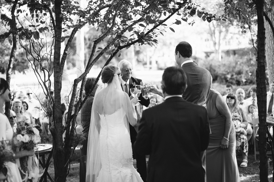 Bride and groom participate in a wine ceremony during A backyard wedding by Detroit Michigan wedding photographer, Heather Jowett.