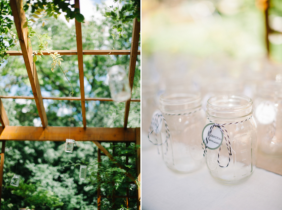 Mason jar votives hang from a trellis at a backyard wedding reception by Ann Arbor Michigan wedding photographer, Heather Jowett.