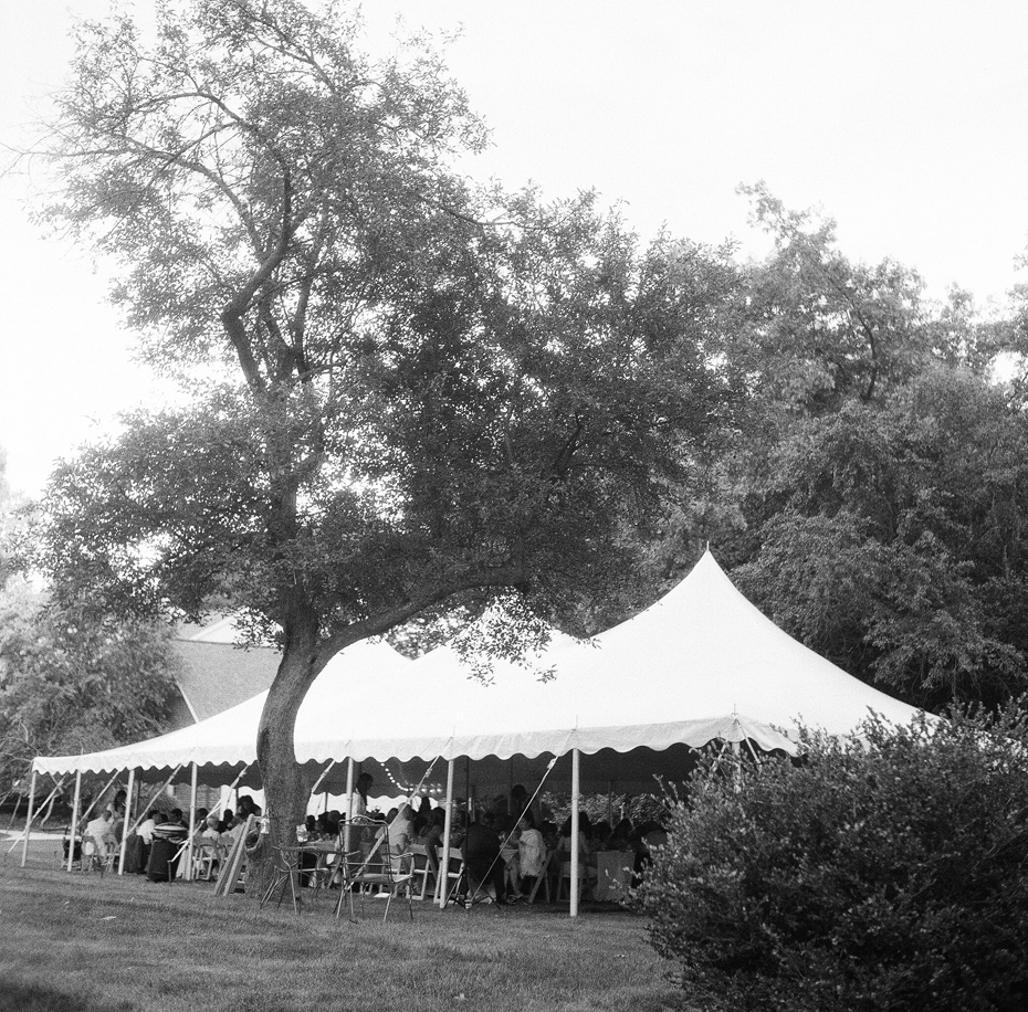 The tent at a backyard wedding reception photographed on black and white film using a vintage rolleiflex by Ann Arbor Michigan wedding photographer, Heather Jowett.