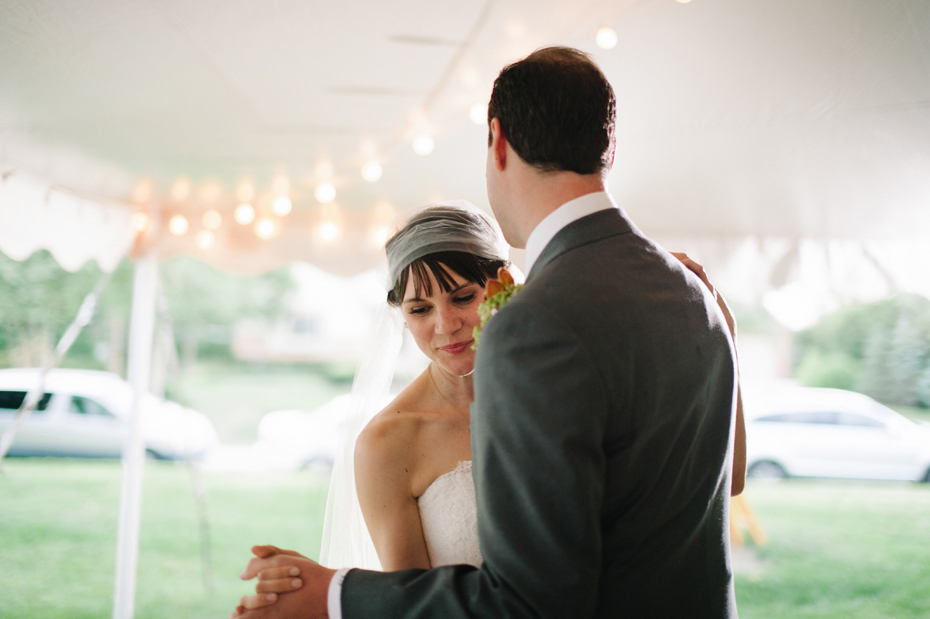 bride and groom share their first dance at their backyard wedding reception by Ann Arbor Michigan wedding photographer, Heather Jowett.