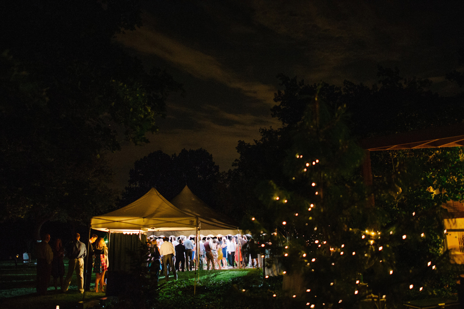 Guests dance in a tent under the stars at a Michigan wedding.