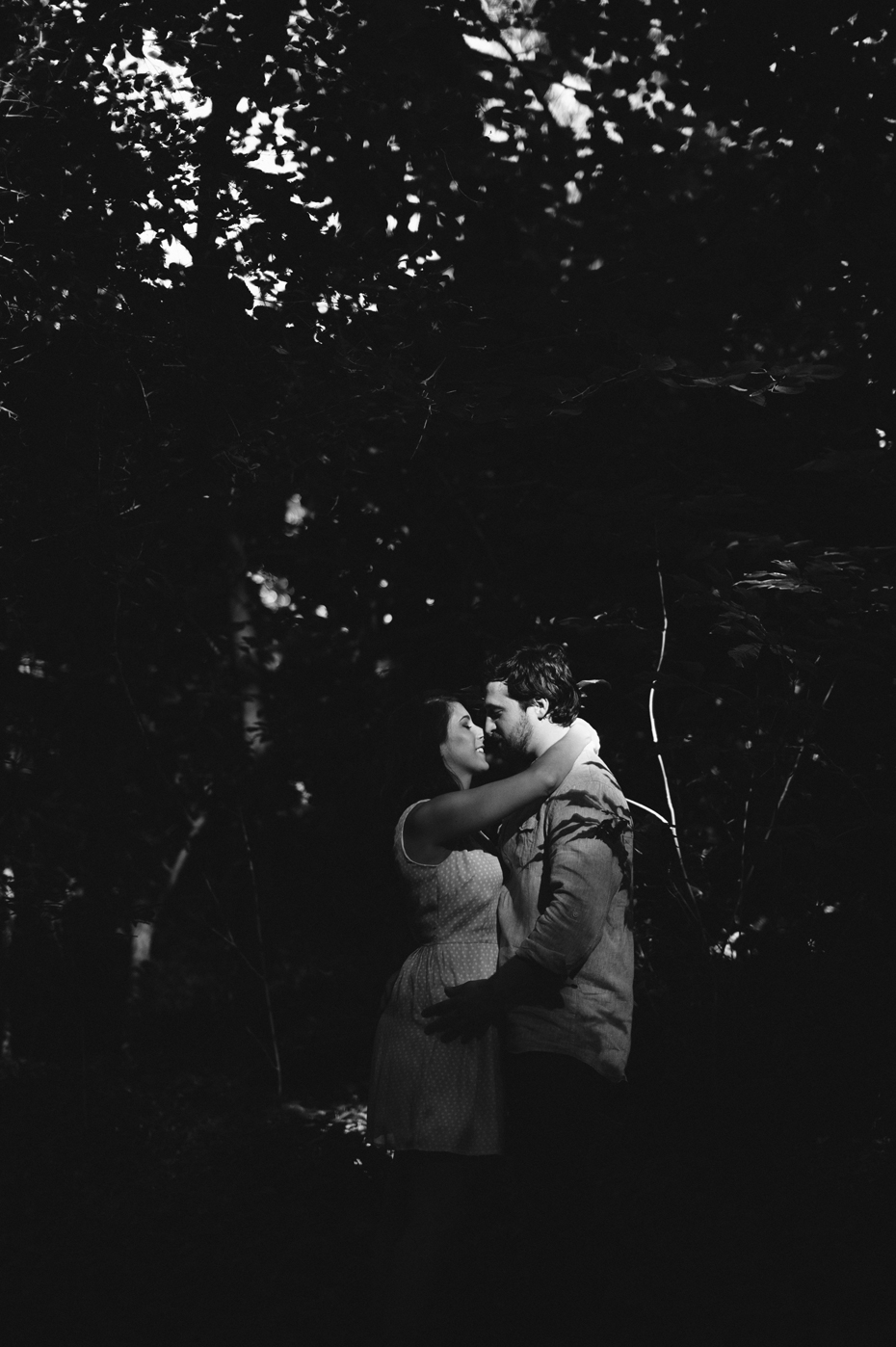 A couple embraces in the woods during a Newport News Virginia engagement session by Ann Arbor Wedding Photographer Heather Jowett.