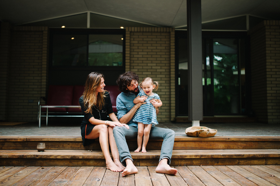 A family poses on their back deck during a lifestyle family portrait session in Ferndale photographed by Ann Arbor Wedding Photographer, Heather Jowett.