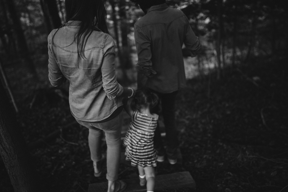 A family journeys to the creek that runs behind their house during a documentary family portrait session in Ferndale photographed by Ann Arbor Wedding Photographer, Heather Jowett.