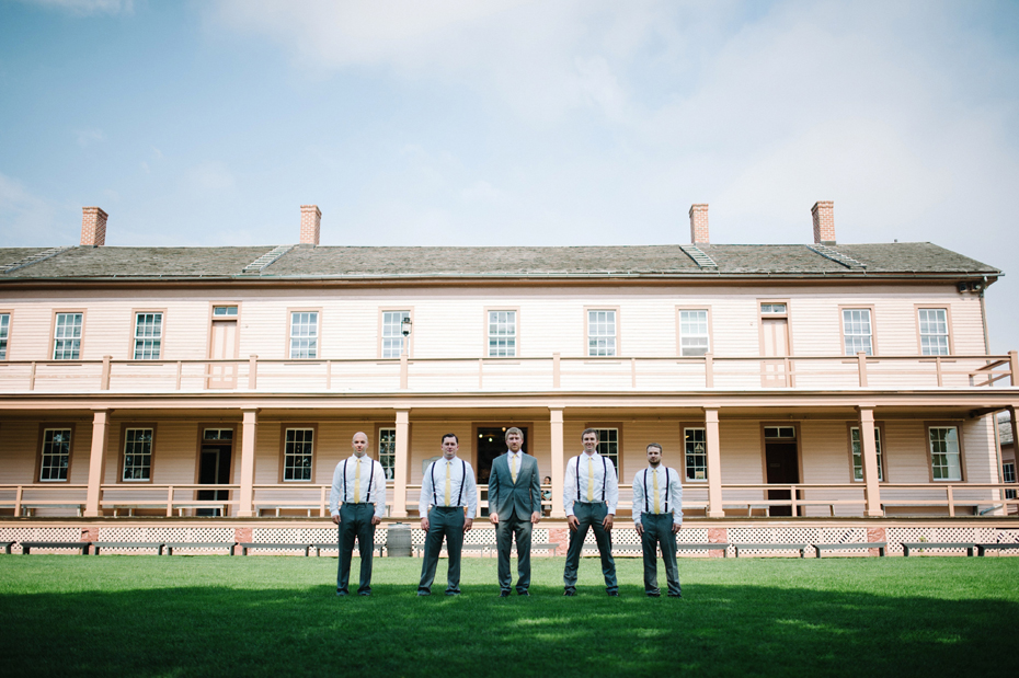 A groom and his groomsmen pose at Fort Mackinac before his wedding at The Inn At Stonecliffe on Mackinac Island by Michigan Wedding Photographer Heather Jowett.