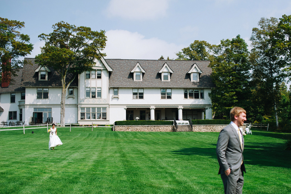 A bride walks to see her groom for their first look at The Inn at Stonecliffe on Mackinac Island by Michigan Wedding Photographer Heather Jowett.