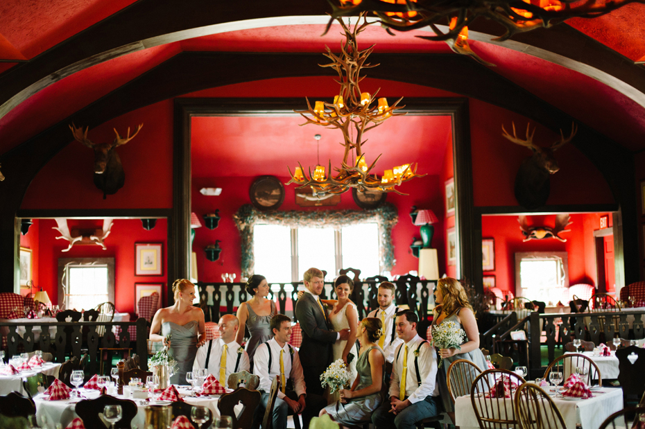 The bridal party poses in dining room at the Woods before a wedding at The Inn at Stonecliffe on Mackinac Island by Michigan Wedding Photographer Heather Jowett.