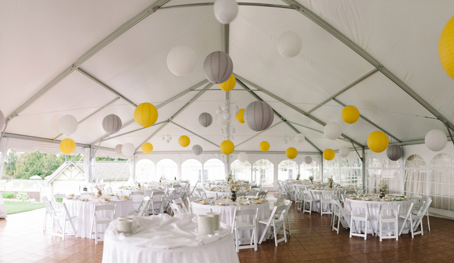 A yellow and grey wedding reception is held in a tent at The Inn at Stonecliffe on Mackinac Island by Michigan Wedding Photographer Heather Jowett.