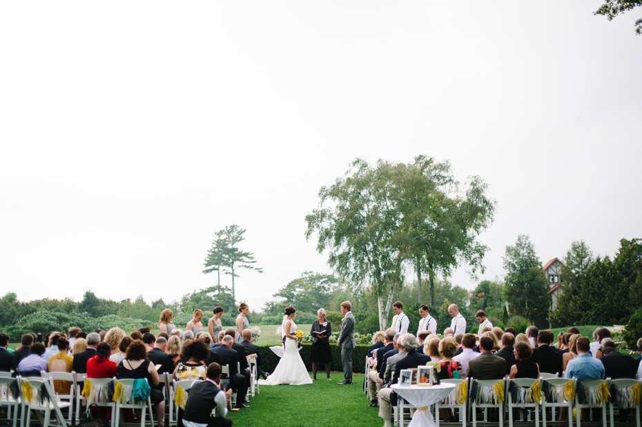 The entire scene of an outdoor wedding ceremony held outside at The Inn at Stonecliffe on Mackinac Island by Detroit Wedding Photographer Heather Jowett.
