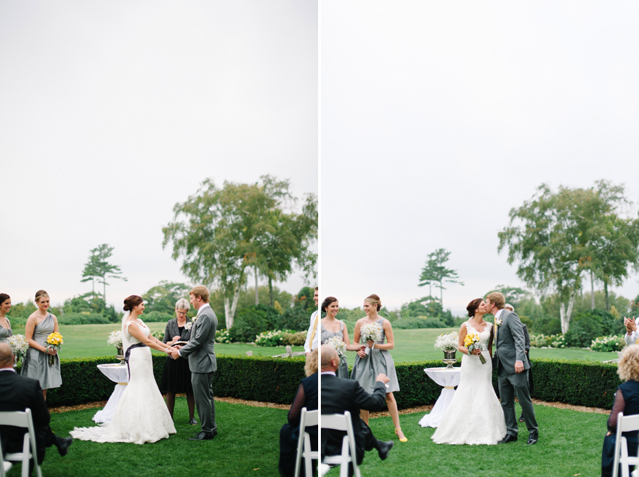 The bride and groom share their first kiss while bells ring during an outdoor wedding ceremony held outside at The Inn at Stonecliffe on Mackinac Island by Detroit Wedding Photographer Heather Jowett.