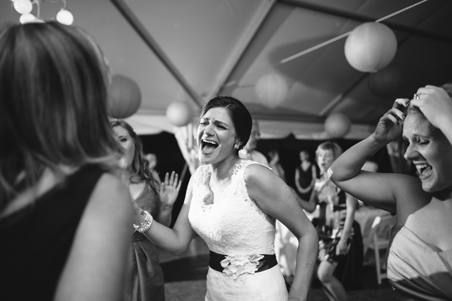 The bride belts out a tune on the dance floor during an outdoor wedding reception at The Inn at Stonecliffe on Mackinac Island by Ann Arbor Wedding Photographer Heather Jowett.