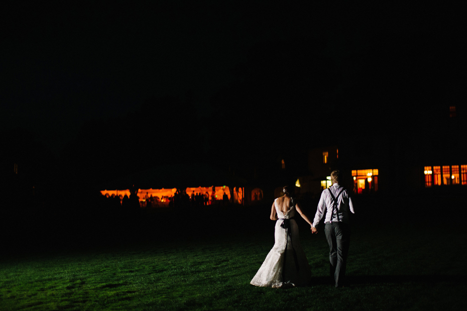 Bride and groom share a quiet moment at night on the back lawn during an outdoor wedding reception at The Inn at Stonecliffe on Mackinac Island by Ann Arbor Wedding Photographer Heather Jowett.