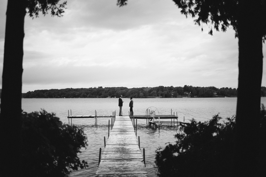 The groom and his friend share a conversation before a morning elopement at the Wheeler Cottage on the shores of Lake Leelanau Michigan by Ann Arbor Michigan Wedding Photographer Heather Jowett.