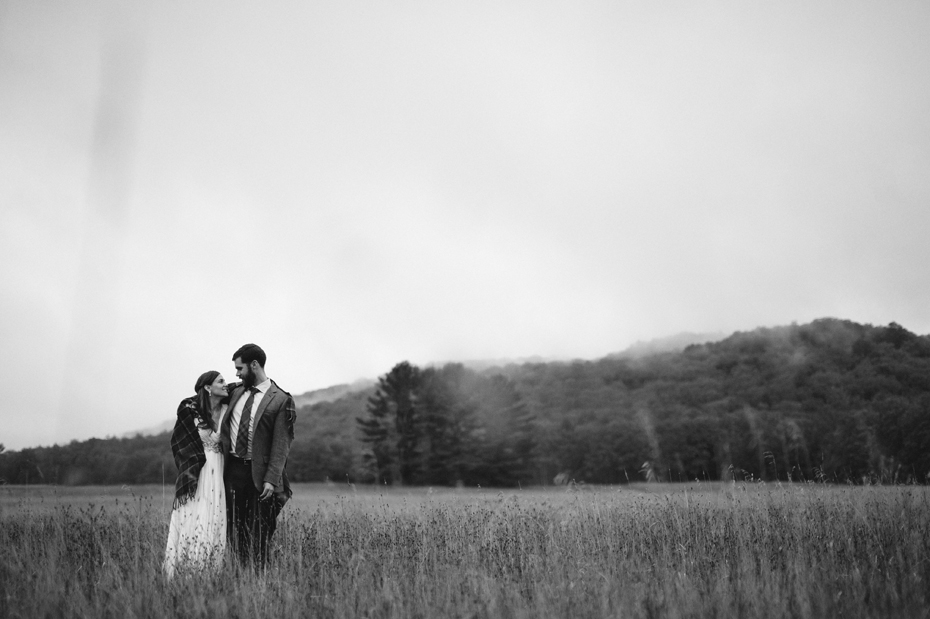 Bride and groom pose for portraits in a Northern Michigan field after their elopement by Ann Arbor Michigan Wedding Photographer Heather Jowett.