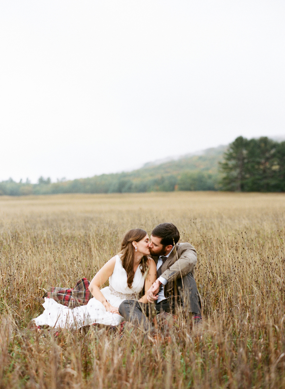 Bride and groom pose for portraits in a Northern Michigan field after their elopement by Ann Arbor Michigan Wedding Photographer Heather Jowett.