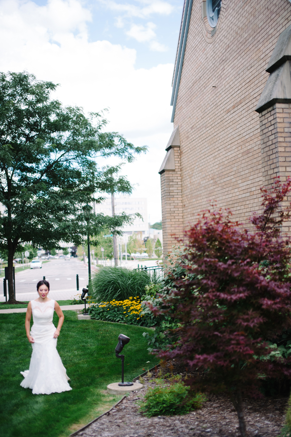 Bride walks to her first look at The Cathedral of Saint Andrew in Grand Rapids Michigan