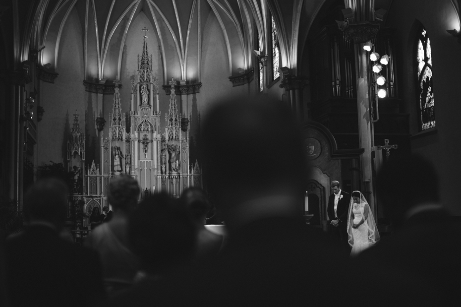 Bride and groom pray during a Catholic wedding ceremony at The Cathedral of Saint Andrew in Grand Rapids Michigan