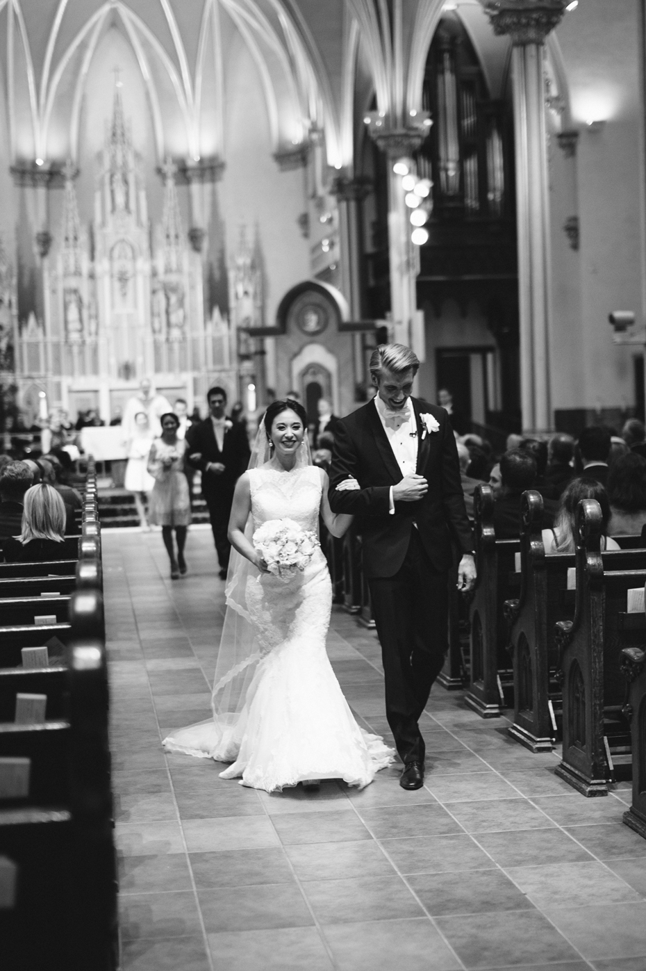 Bride and groom exit the church at The Cathedral of Saint Andrew in Grand Rapids Michigan
