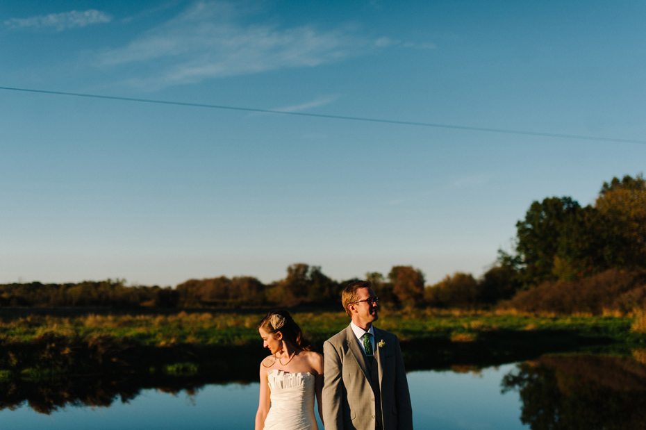 Bride and groom pose by the pond at Misty Farms in Ann Arbor MI.