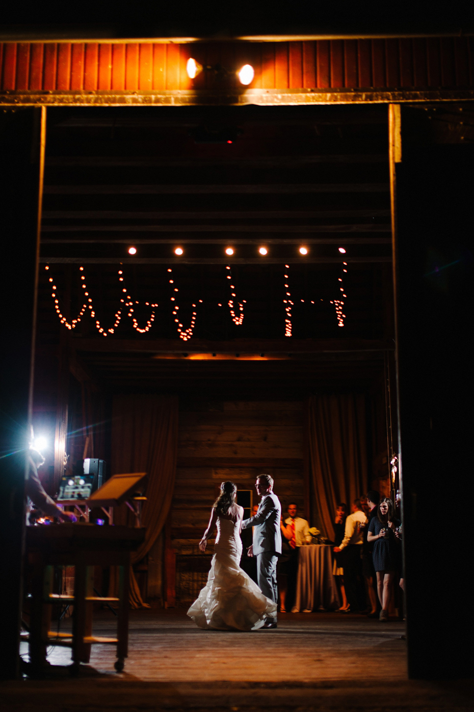 Bride and groom share a first dance in the barn at a wedding reception at Misty Farms by photojournalistic Michigan wedding photographer Heather Jowett.