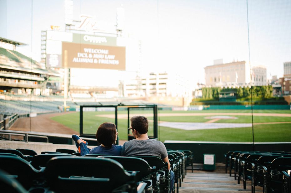 A couple enjoying the view of the field during their engagement session at Comerica Park.