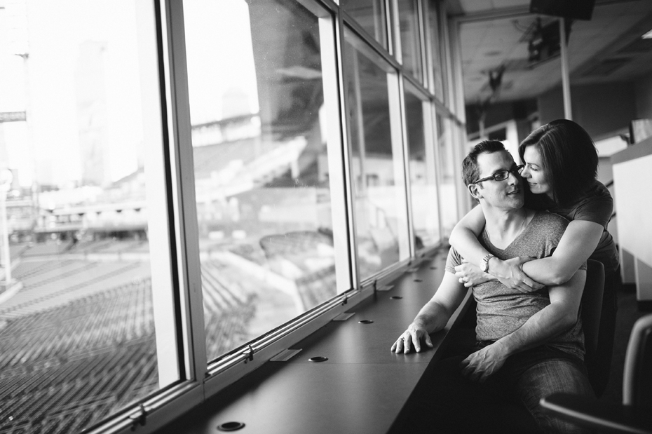 A couple posing in the press box during their engagement session at Comerica Park.