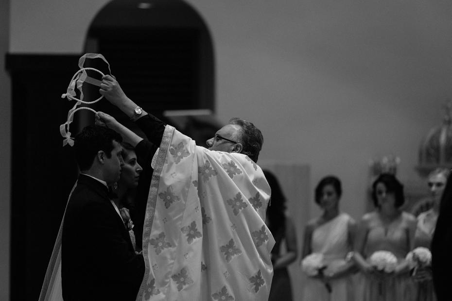 The bride and groom are crowned at Saints Constantine & Helen Greek Orthodox Church in Newport News by Virginia Wedding Photographer, Heather Jowett.