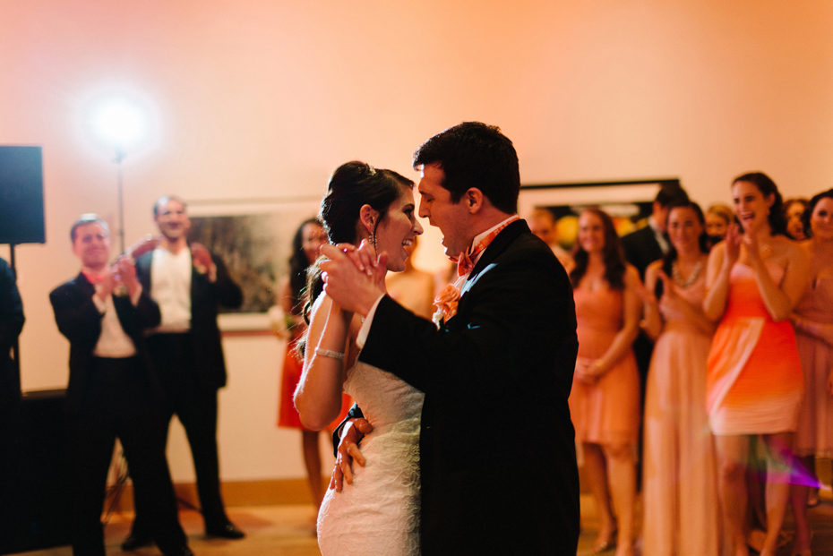 A couple dances with amber uplighting at a PFAC Peninsula Fine Arts Center Wedding.