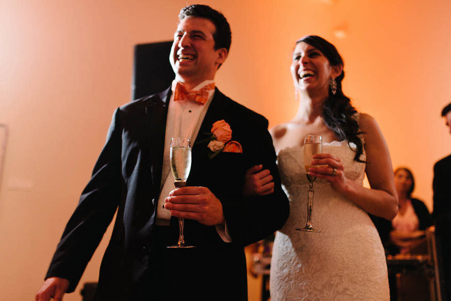Bride and groom share a laugh at a wedding reception at PFAC, the Peninsula Fine Arts Center in Newport News by Virginia Wedding Photographer, Heather Jowett.
