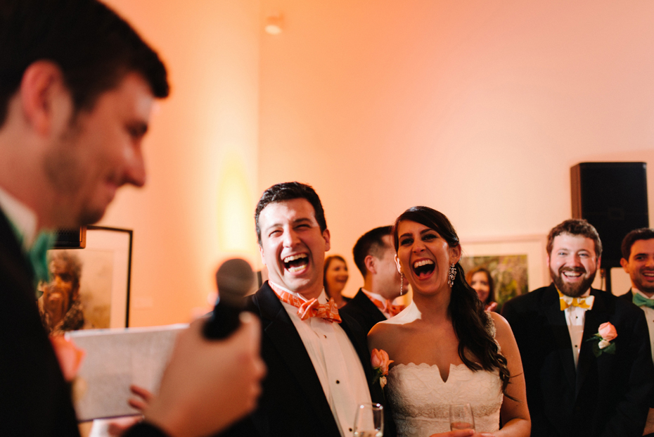 The bride and groom laugh at a wedding reception at PFAC, the Peninsula Fine Arts Center in Newport News by Virginia Wedding Photographer, Heather Jowett.