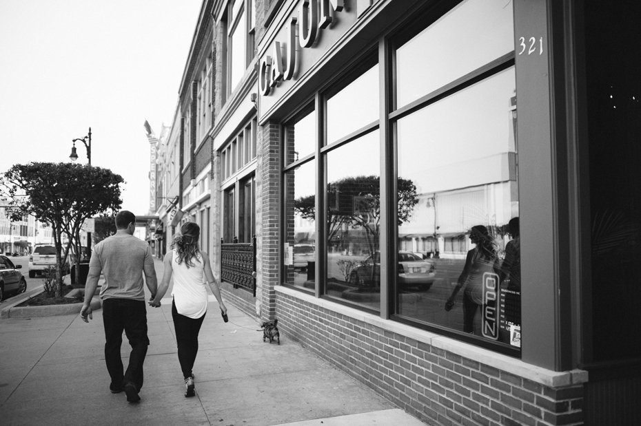 A couple takes a stroll with their dog during their engagement session by Detroit Michigan wedding photographer Heather Jowett.