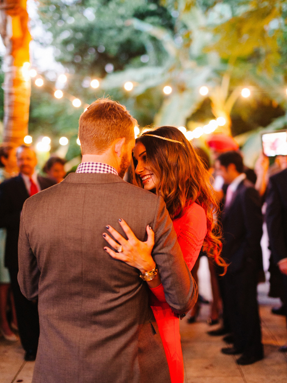 The bride and groom share a first dance under patio lights at the Sundy House in Southern Florida by wedding photographer Heather Jowett.