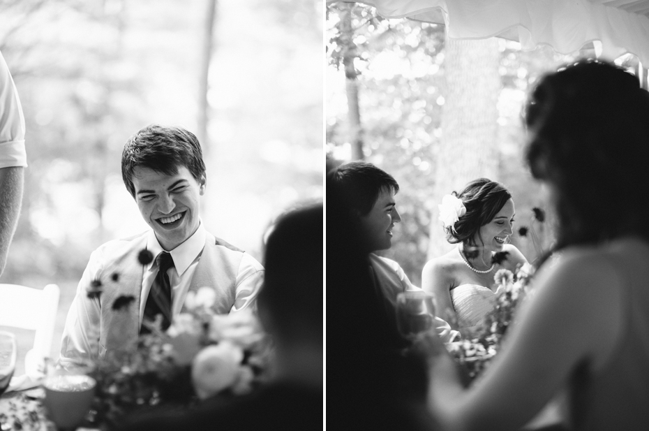 Bride and groom laughing at toasts at a rustic yellow and white wedding.