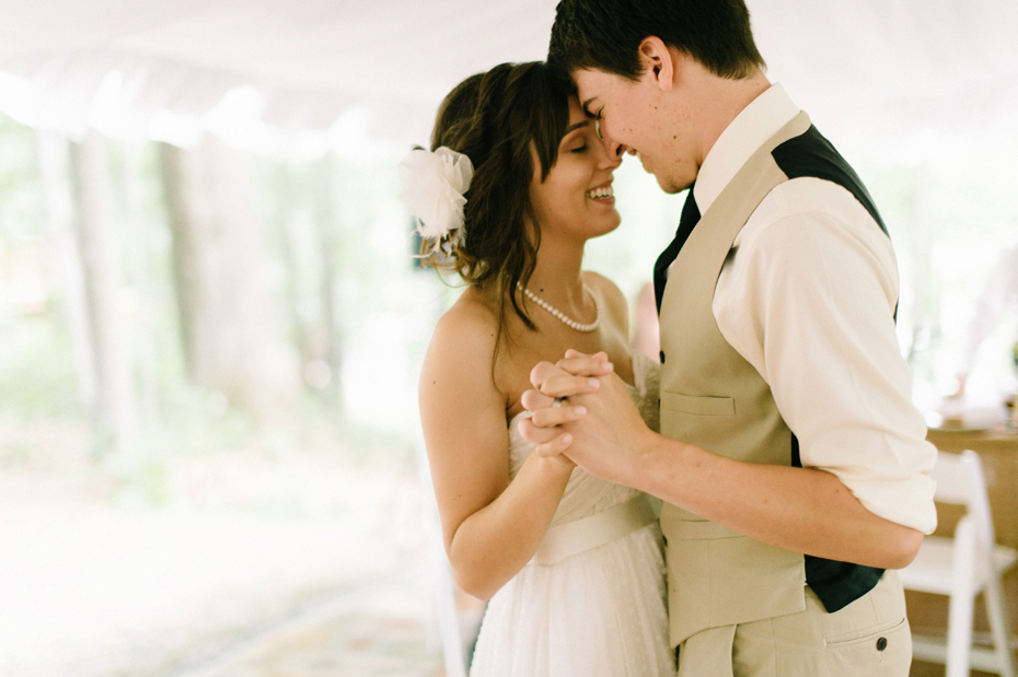 Bride and groom sharing an emotional first dance at their rustic wedding by photojournalistic wedding photographer heather jowett.