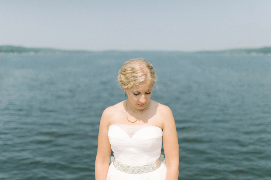 Bride by the water in East Jordan Michigan by Ann Arbor Wedding Photographer Heather Jowett.