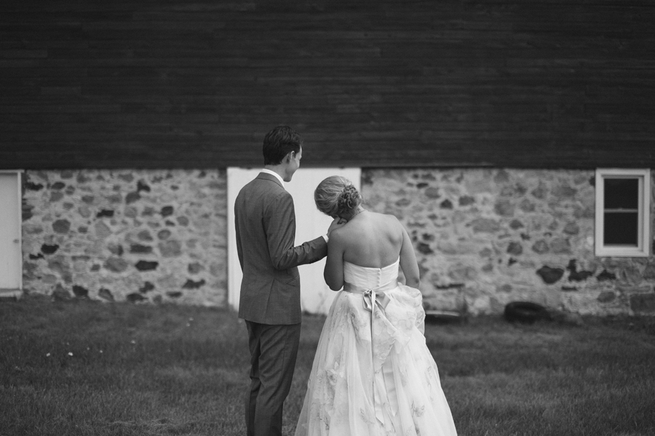 Bride and groom portrait by a barn by Michigan wedding photographer Heather Jowett.