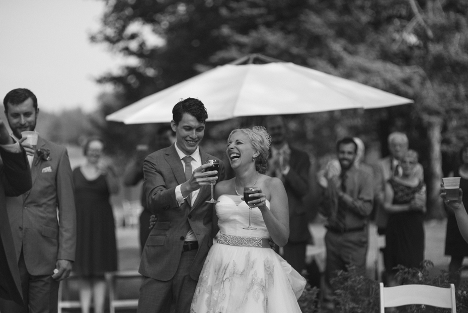 The bride and groom laugh at the best man's toast at Tapawingo in Northern Michigan by Ann Arbor Wedding Photographer Heather Jowett.