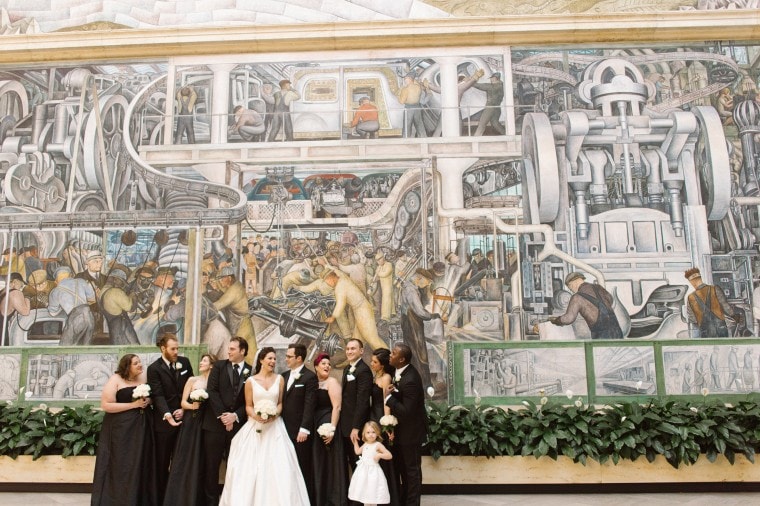The wedding party poses for a photograph in the Rivera court of the Detroit Institute of Arts.